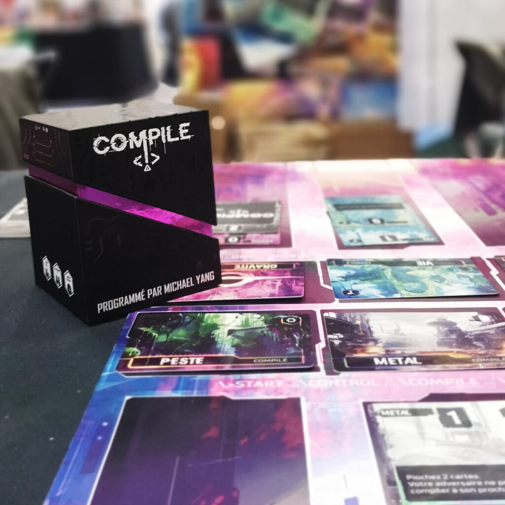 La boite du jeu Compile et son tapis de jeu
