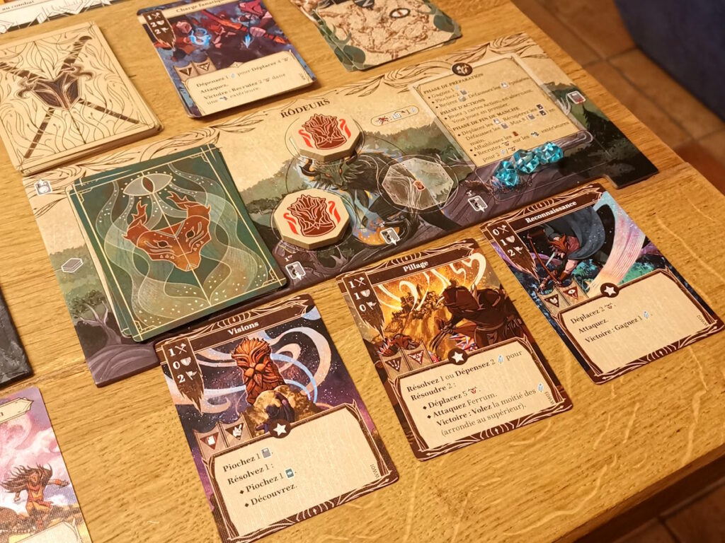 Le plateau du joueur Rôdeur à la fin d'une manche, avec les trois cartes Actions jouées.